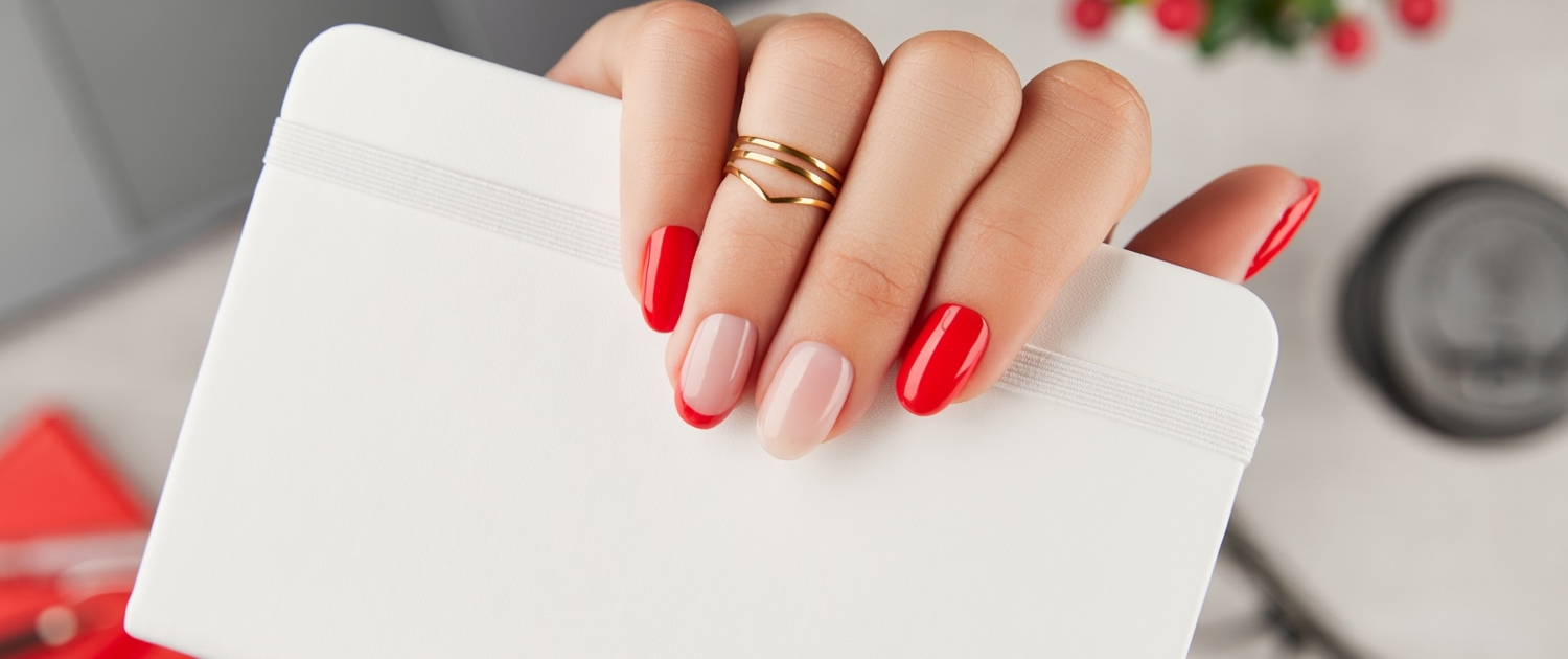 Womans hand with trendy manicure holding notepad over table. Manicure design trends